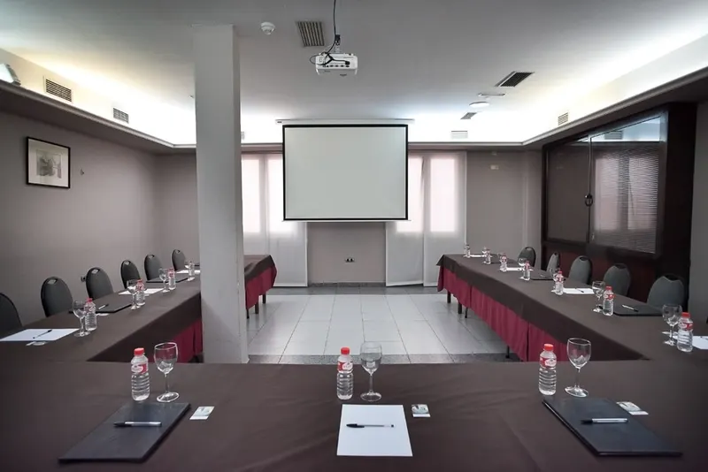 Salón de reuniones preparado en U con proyector